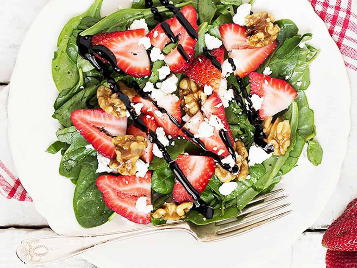 strawberry spinach salad on white plate