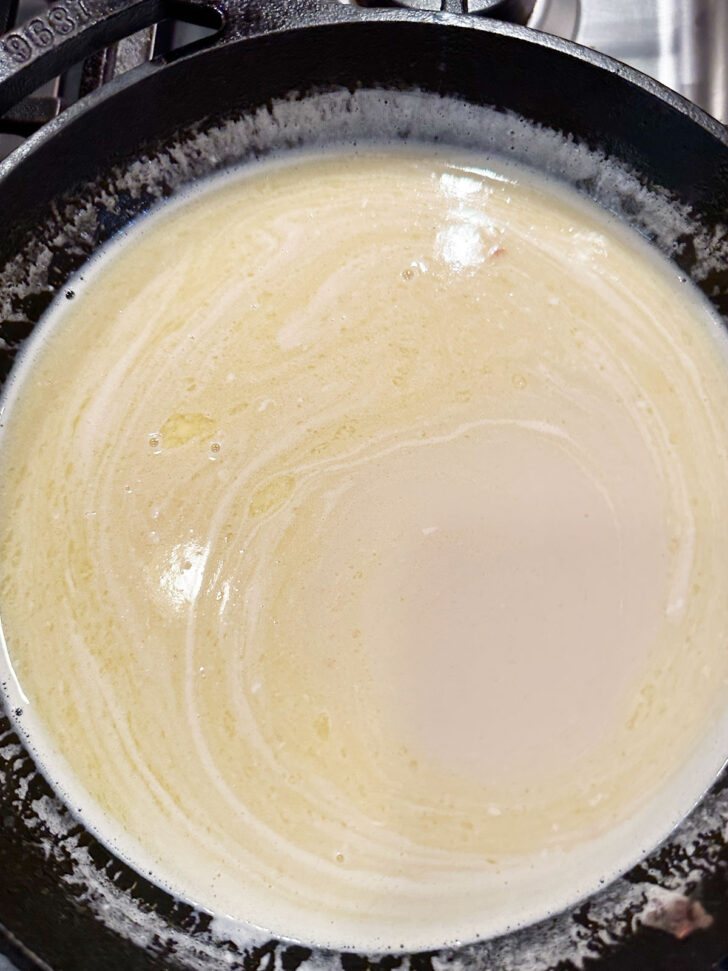Warming the milk and brown sugar in a skillet.