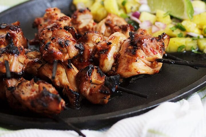 grilled chicken skewers on plate with pineapple salsa