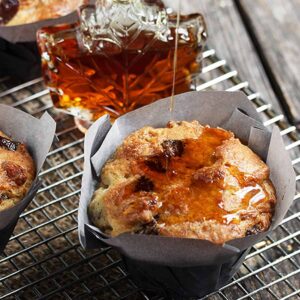 butter tart muffins on cooling rack with maple syrup bottle