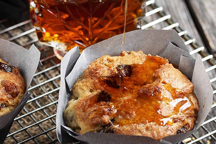 butter tart muffins on cooling rack with maple syrup bottle