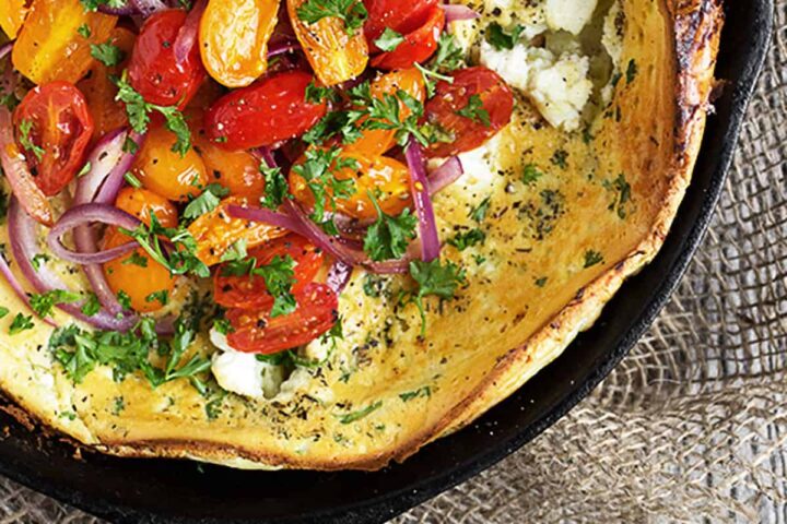 Dutch baby with cherry tomatoes and goat cheese on top