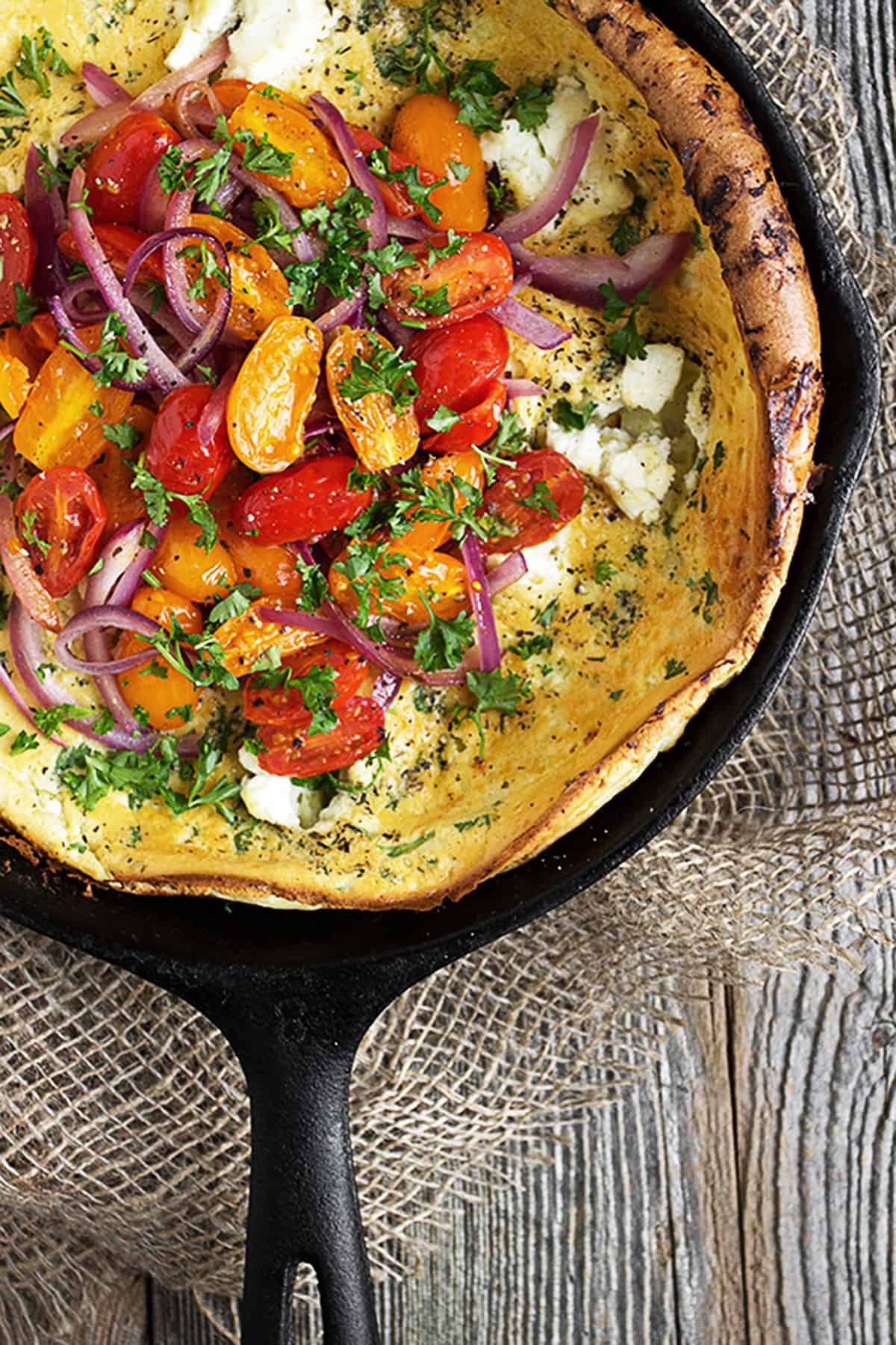 Dutch baby with cherry tomatoes and goat cheese on top