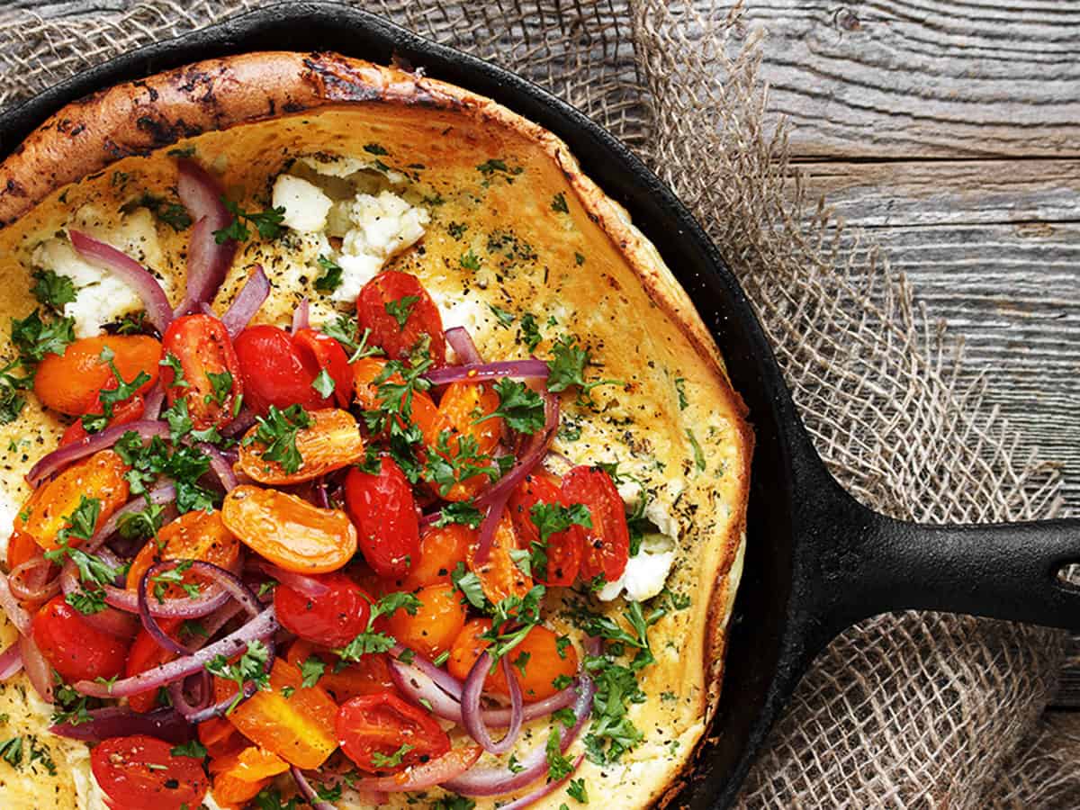 Dutch baby with cherry tomatoes and goat cheese on top