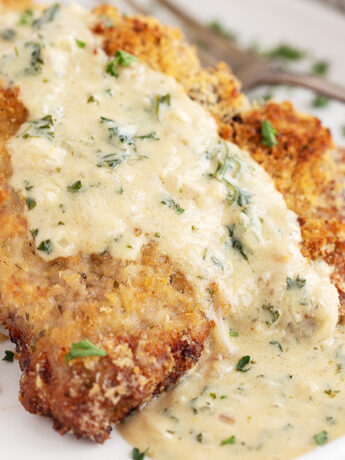 Oven-baked panko breaded pork chops on plate with mustard sauce.