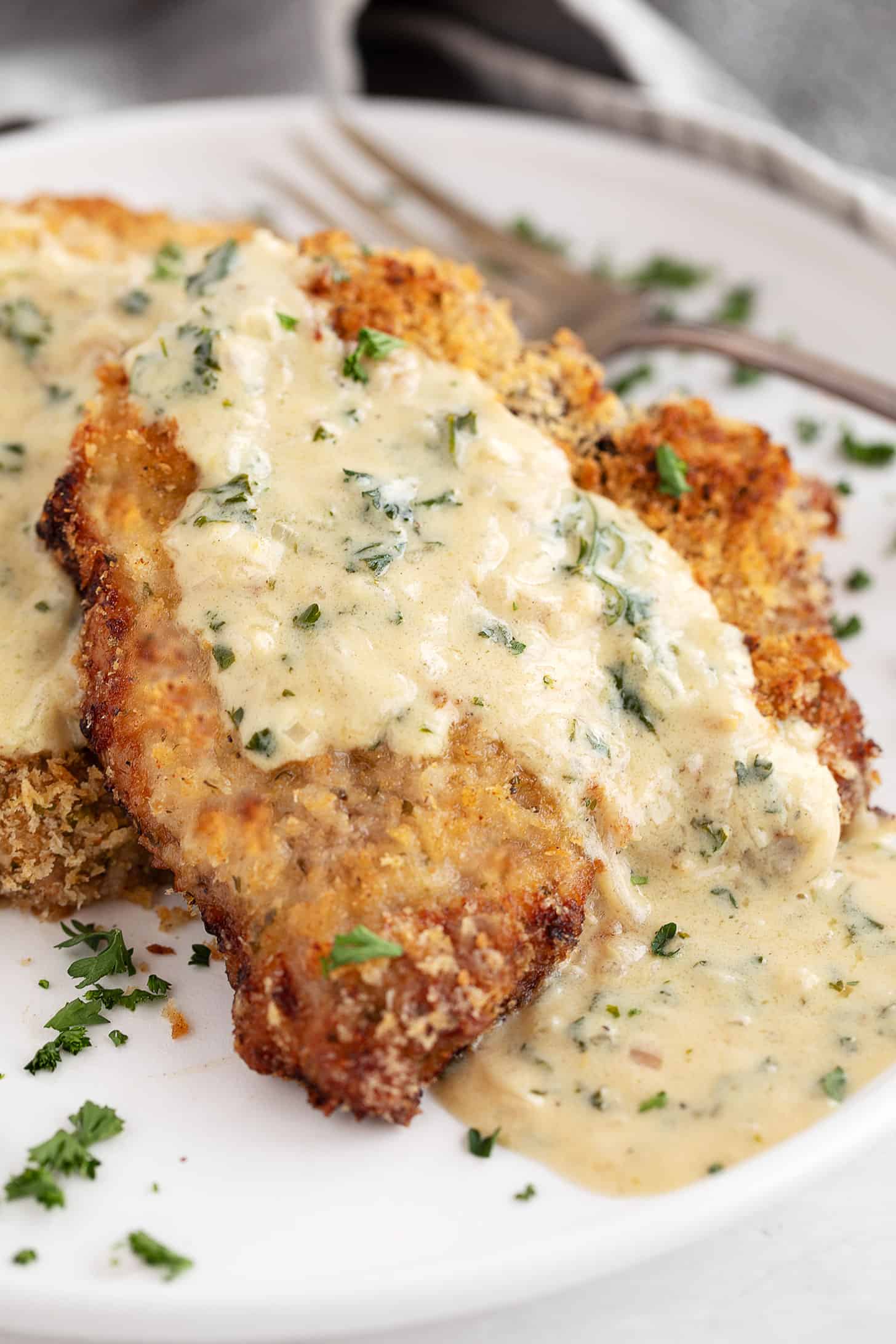 Oven-baked panko breaded pork chops on plate with mustard sauce.