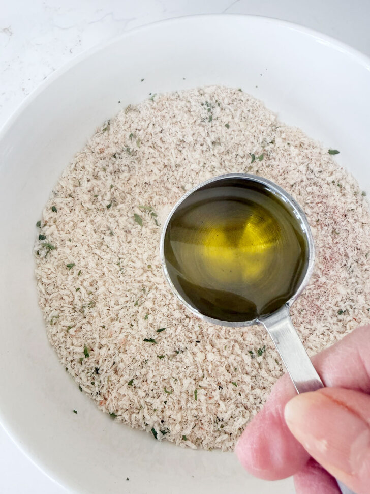 Adding oil to the panko breading ingredients.