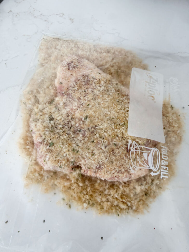 Pork chops added to panko breading in the plastic zipper bag.