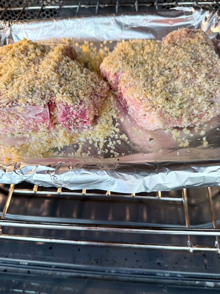 Panko breaded pork chops being placed into the oven.