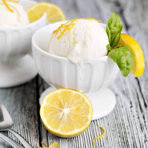 no-churn lemon ice cream in ice cream bowls with lemons