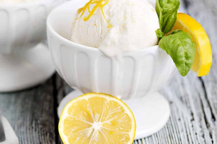 no-churn lemon ice cream in ice cream bowls with lemons