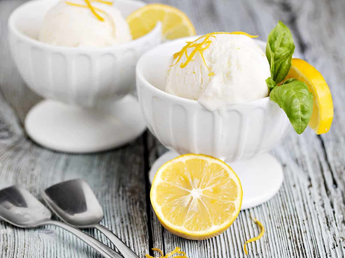 no-churn lemon ice cream in ice cream bowls with lemons