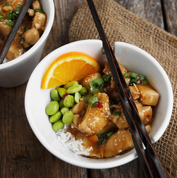 orange peel chicken in bowl with rice and edamame