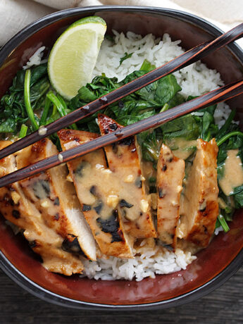 Pork Rice Bowl with Peanut Sauce in bowl with chopsticks.