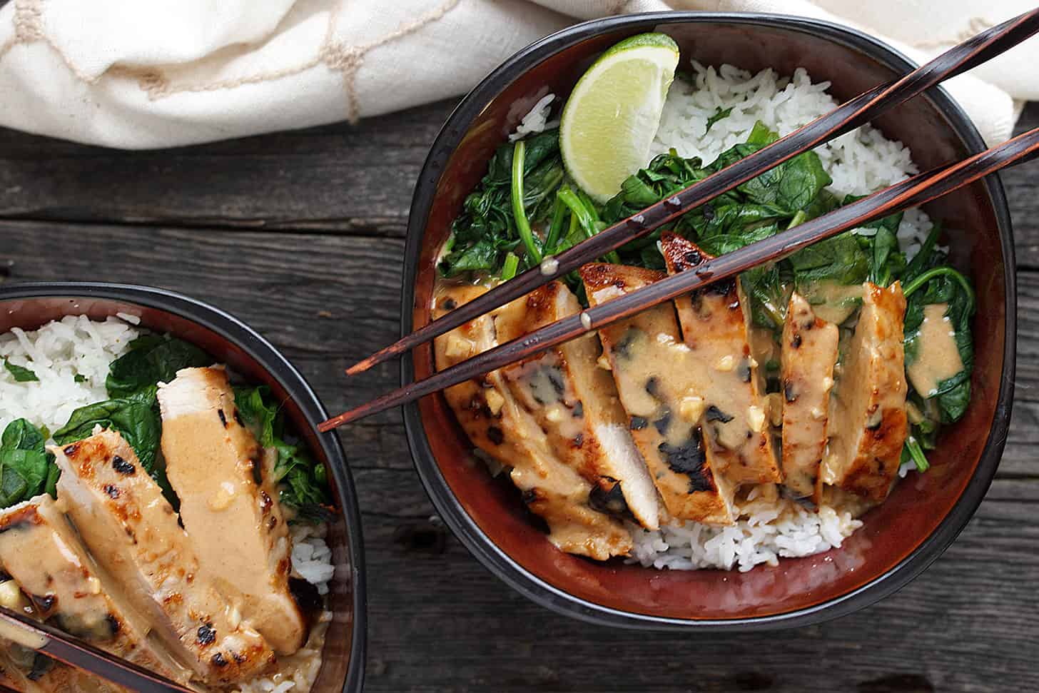 Pork Rice Bowl with Peanut Sauce in bowl with chopsticks.