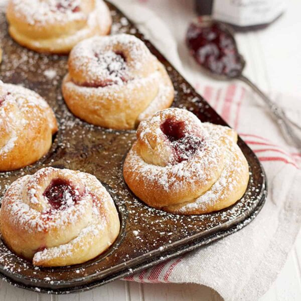 rose shaped buns in muffin tin with raspberry jam