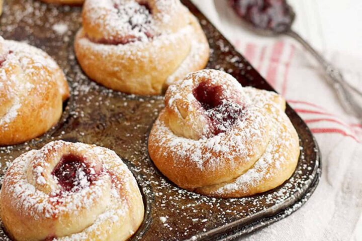 rose shaped buns in muffin tin with raspberry jam
