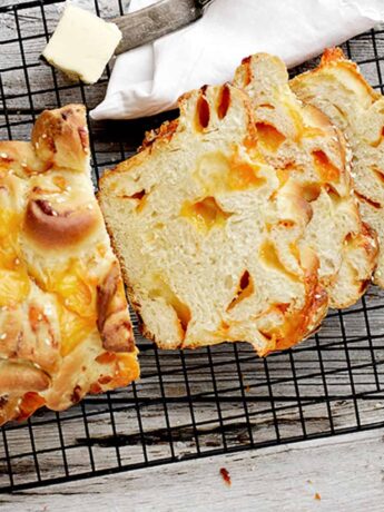 homemade chunky cheese bread sliced on cooling rack