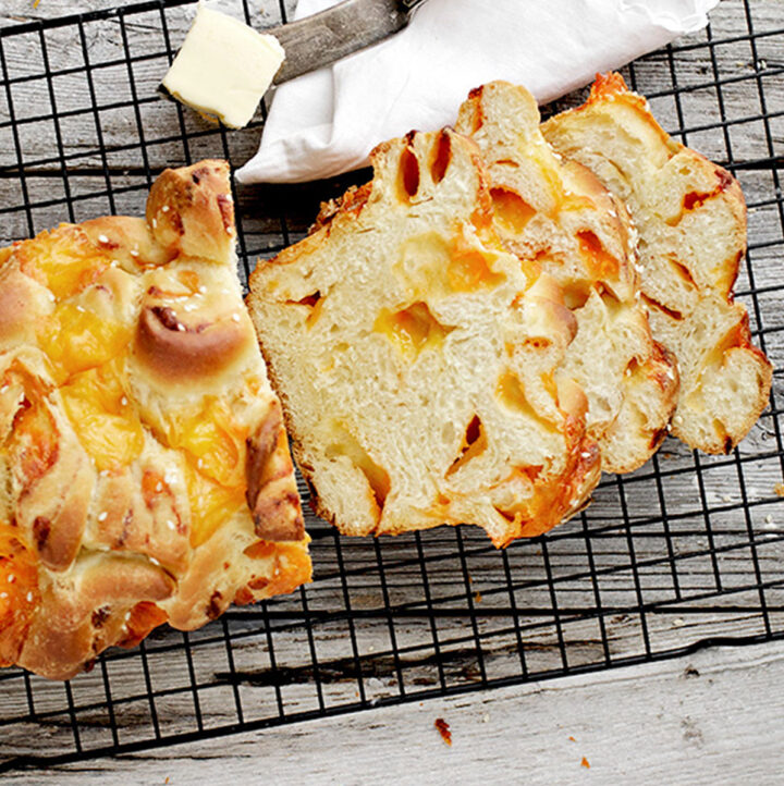 homemade chunky cheese bread sliced on cooling rack