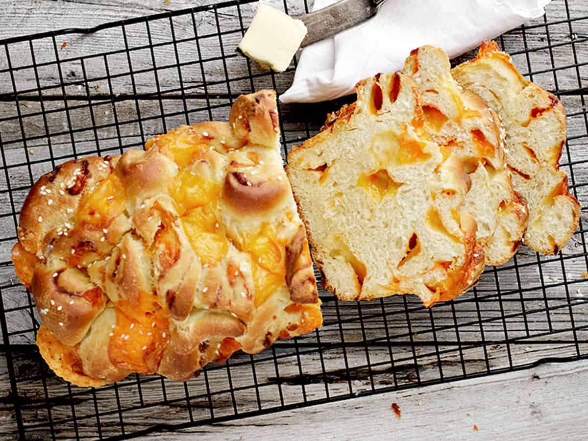 homemade chunky cheese bread sliced on cooling rack