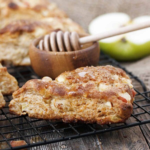 apple buttermilk scones on cooling rack with honey