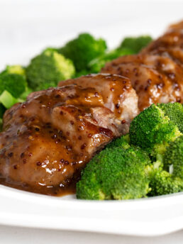 maple mustard pork tenderloin sliced on plated with broccoli