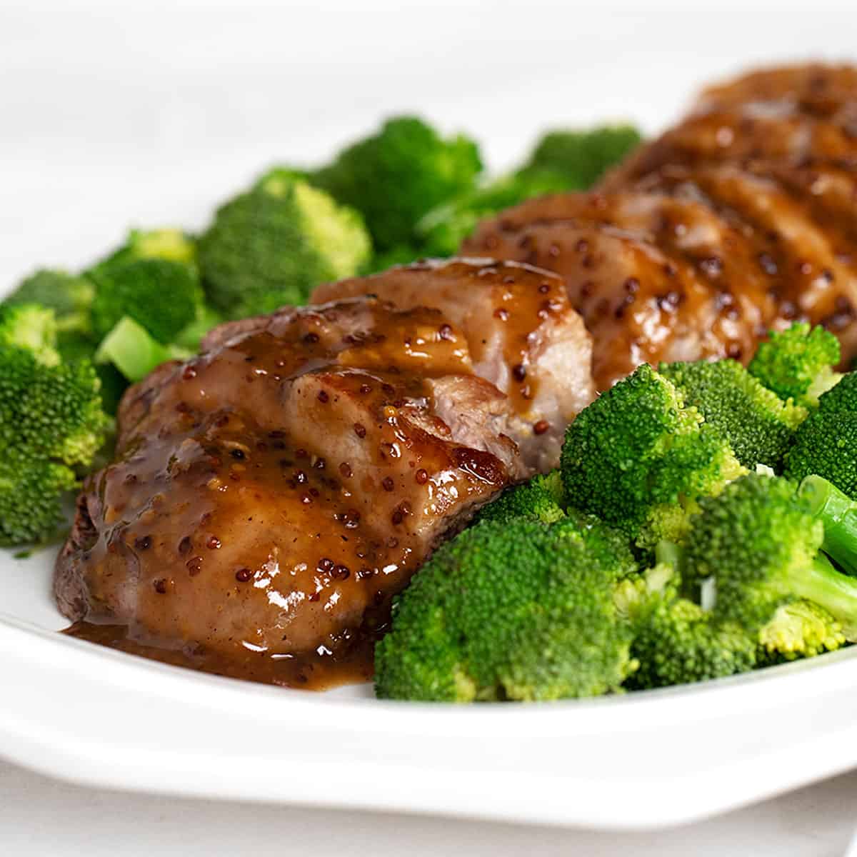 maple mustard pork tenderloin sliced on plated with broccoli