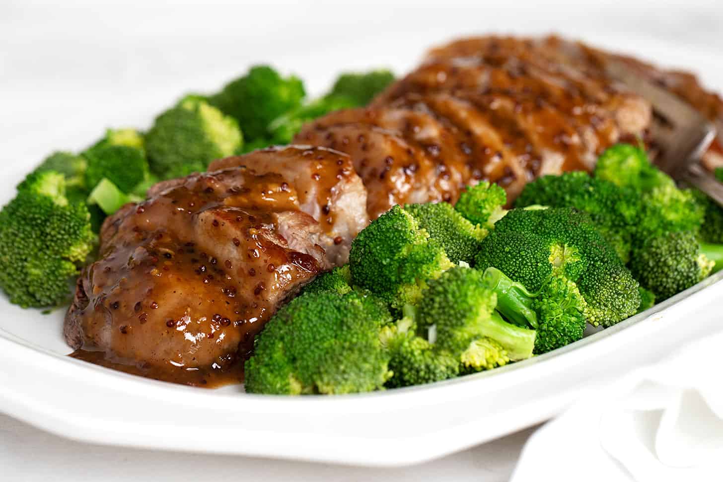 maple mustard pork tenderloin sliced on plated with broccoli