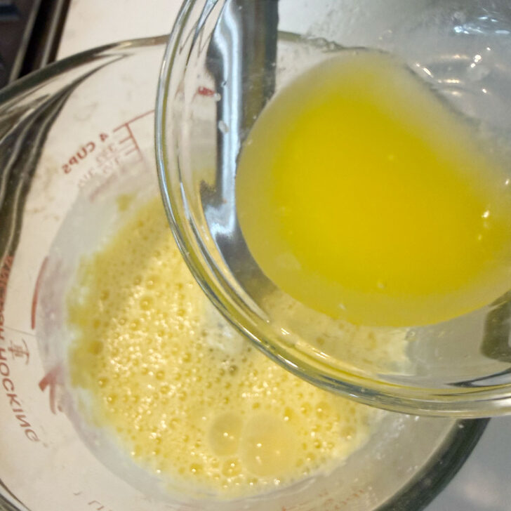 Adding the cooled melted butter to the mini Dutch baby batter.