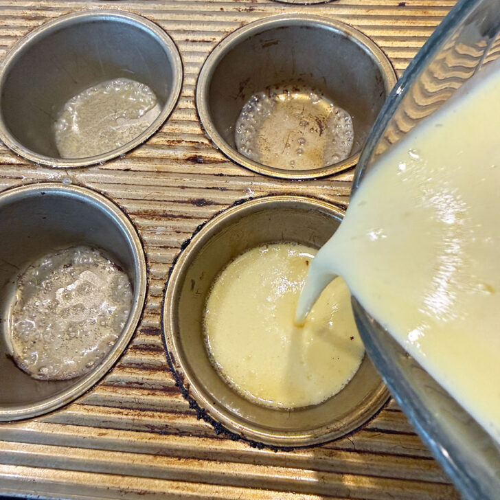 Pouring the mini Dutch baby batter into the buttered muffin cups.