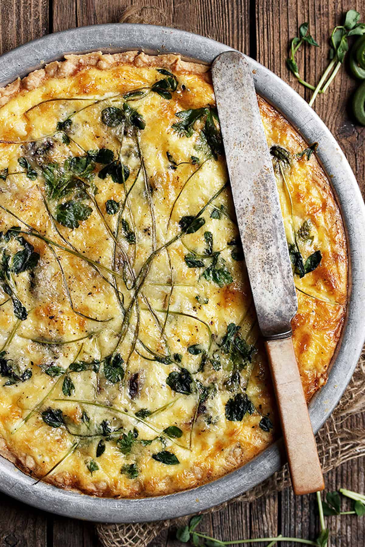 fiddlehead quiche in pie plate with knife