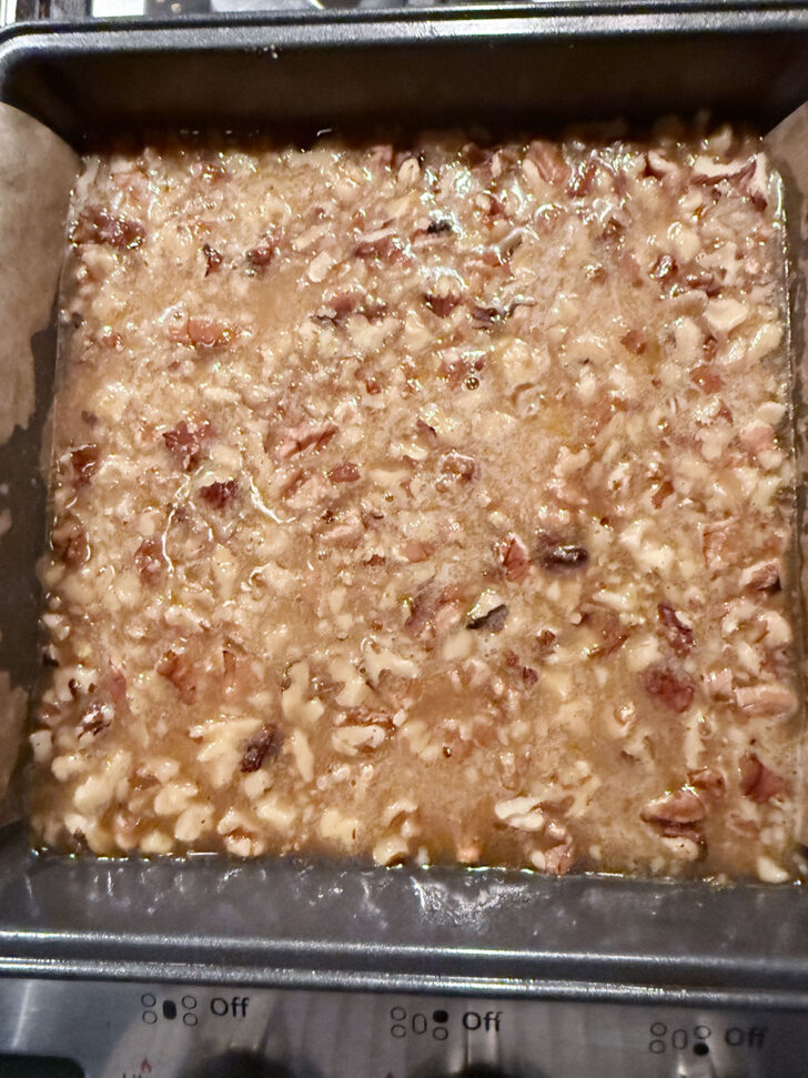Filling poured over the walnuts in the pan.
