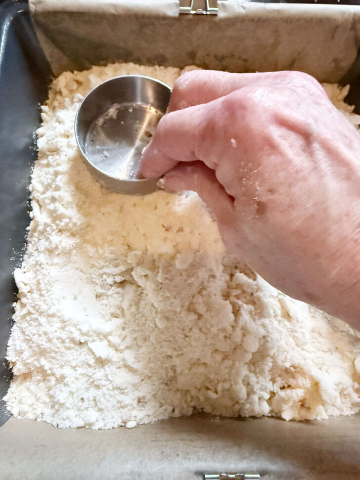 Pressing the crumb mixture into the pan.