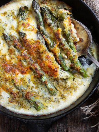 baked asparagus with cheese sauce in cast iron skillet