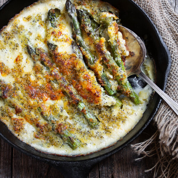 baked asparagus with cheese sauce in cast iron skillet