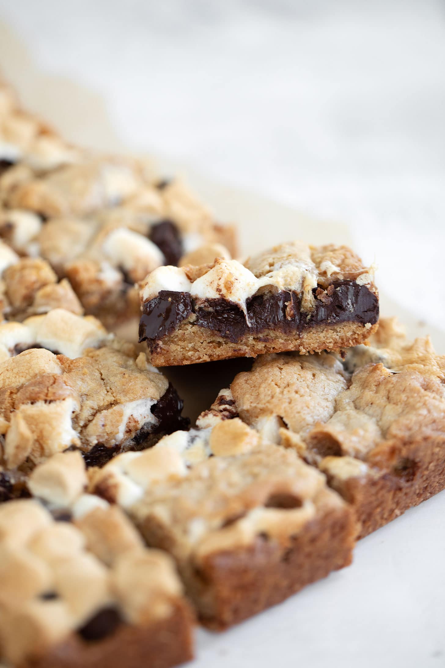 S'mores cookie bars cut on parchment paper.