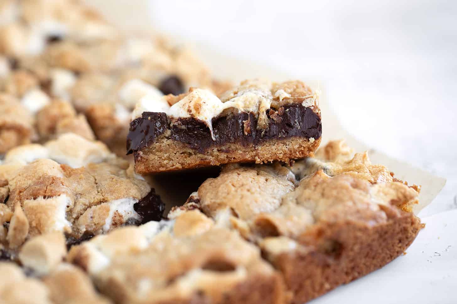 S'mores cookie bars cut on parchment paper.