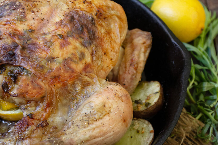 tarragon and lemon roasted whole chicken in skillet