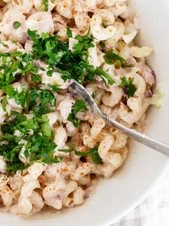 Tuna pasta salad in salad bowl with spoon.