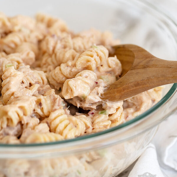 tuna pasta salad in bowl with wooden spoon