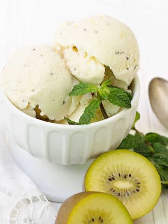 kiwi ice cream scooped in cup with sliced kiwis