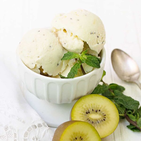 kiwi ice cream scooped in cup with sliced kiwis
