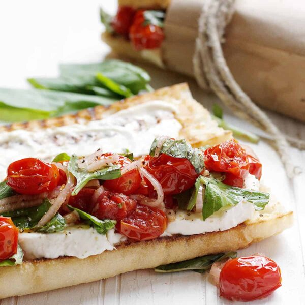 blistered tomato caprese sandwiches on white background