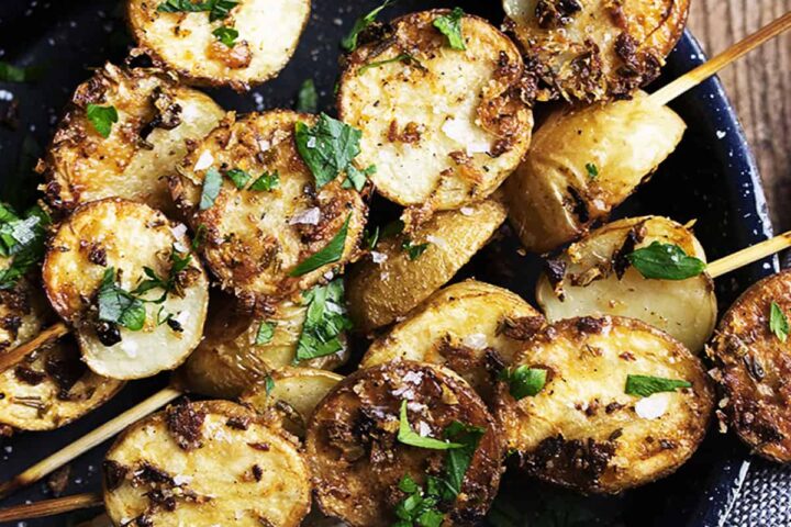 herb and garlic potato skewers in small skillet