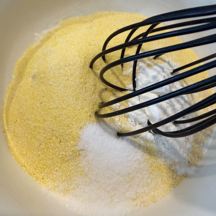 Cornmeal, flour and baking powder in a mixing bowl.