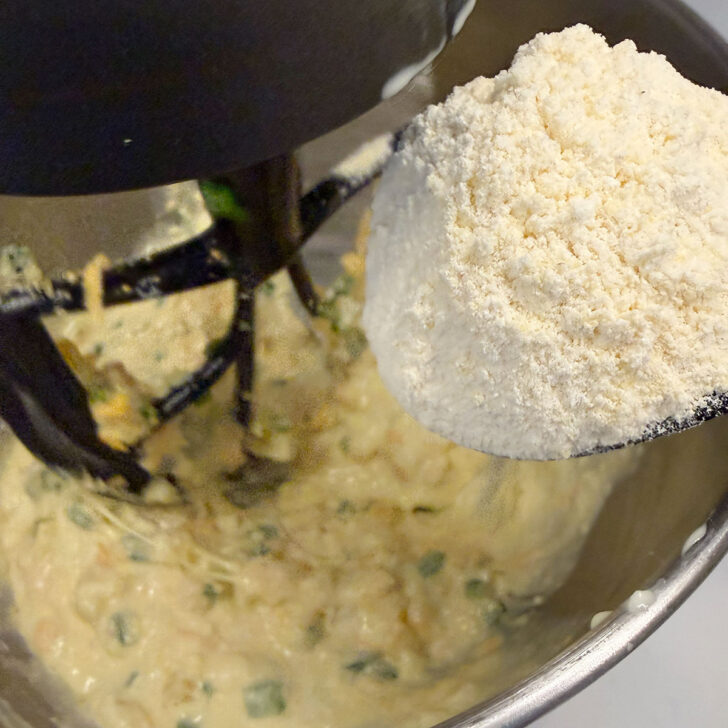 Adding the flour mixture to the cornmeal batter.