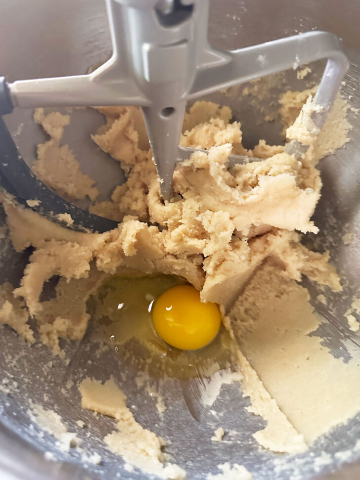 adding egg to dough in mixer