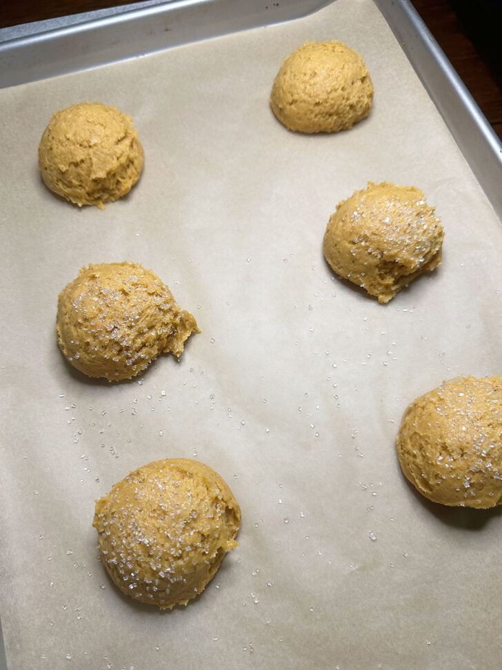 scoops of dough on baking sheet sprinkled with sugar before baking