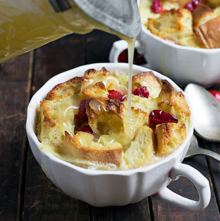 cranberry orange bread pudding with warm butter sauce being poured
