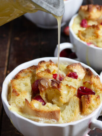 cranberry orange bread pudding with butter sauce being poured